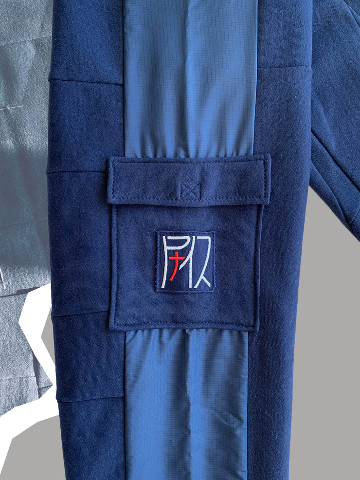 B-Jog 28 upcycling bleu, zoom sr la patch brodé du logo argenté et rouge, cousu sur la poche plaquée 