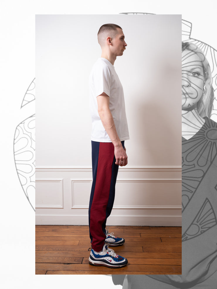 Nann, B-Jog bicolore en coton et plastique recyclé, porté par Remi vue de côté, bande rouge, jambe droite