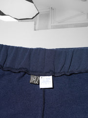 K-Short bleu, en coton et plastique recyclés, détail des etiquettes logo, taille et composition cousues dans la ceinture, en milieu dos