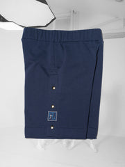 K-Short bleu, en coton et plastique recyclés, bande côté à boutons pressions et patch brodé logo cousu en bas 