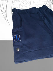 Nann, Mini short, bleu, coton et plastique recyclés, focus sur la bande de côté à pressions, patch brodé bicolore